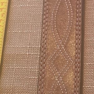 Brown leather belt with large red enamel buckle